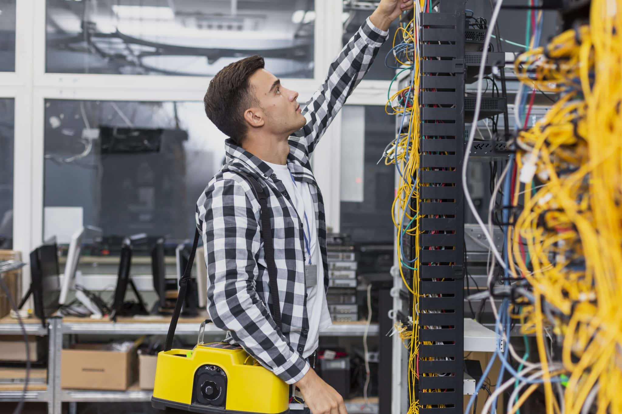 Technician reviewing network cabinet cabling and connection points