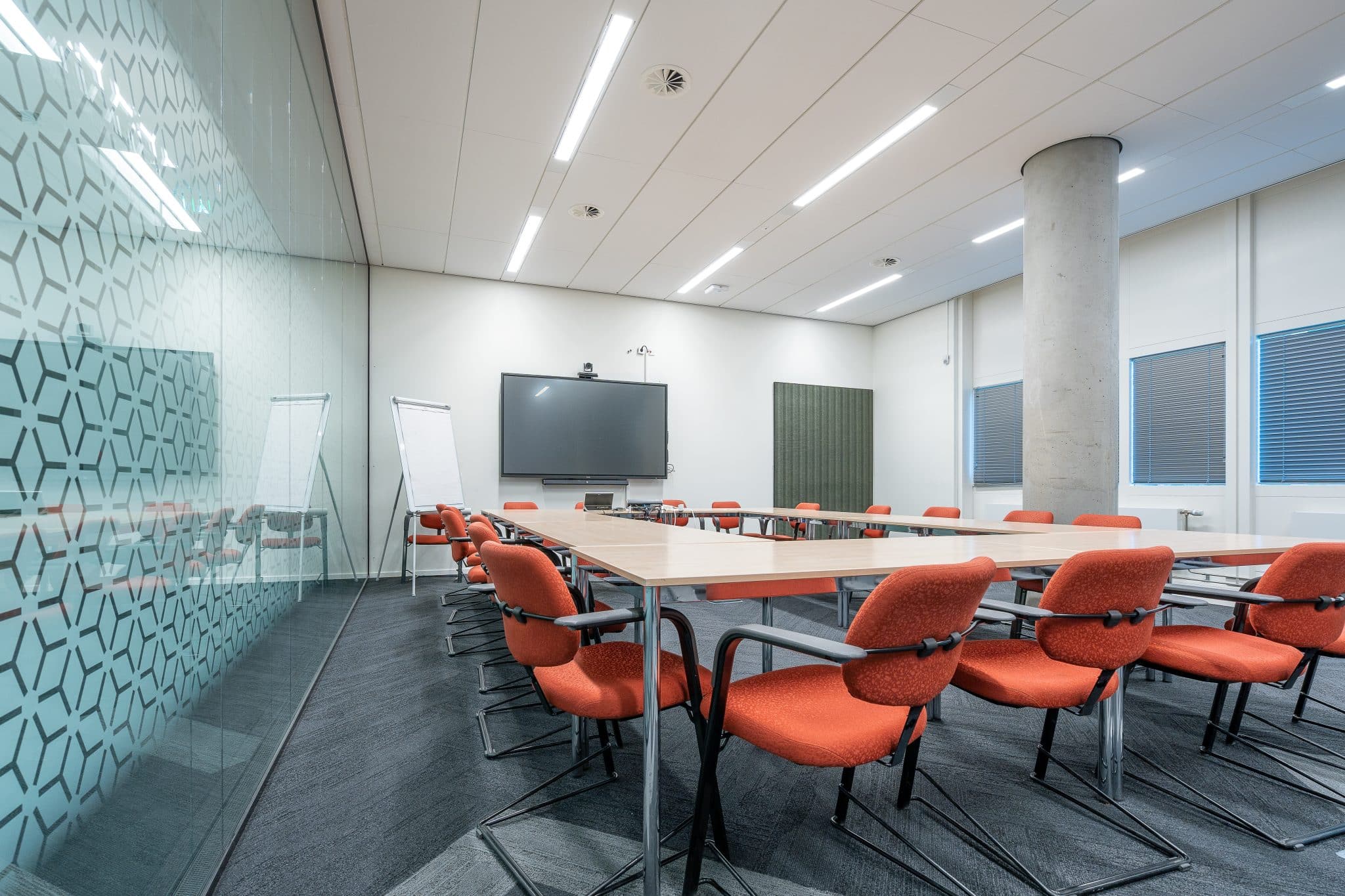 Commercial meeting room with a wall-mounted display and conferencing camera